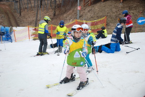 Zdjęcie kolorowe wykonane w porze dziennej przedstawia stok narciarski w Przemyślu. Na zdjęciu widoczne są dzieci  które biorą udział w konkursach.
