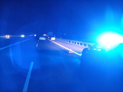 radiowóz policyjny z włączonymi światłami błyskowymi w miejscu zdarzenia drogowego na autostradzie A4