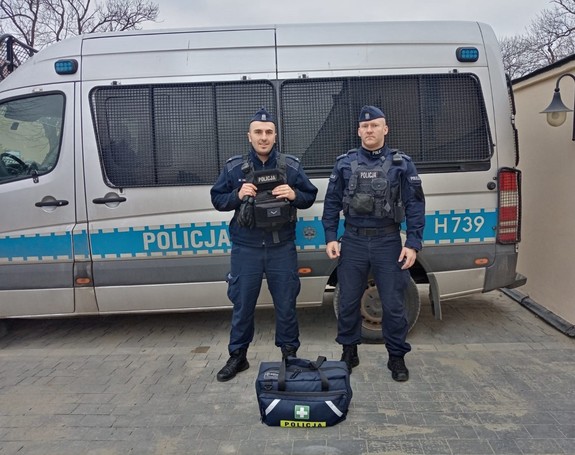 Zdjęcie kolorowe przedstawia dwóch funkcjonariuszy policji którzy uratowali życie kobiece jadącej w pociągu  relacji Przemyśl-Kraków