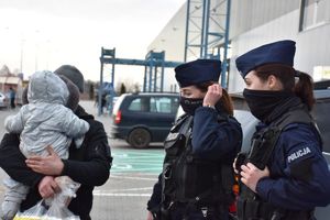 dwie policjantki obok nich mężczyzna trzymający niemowlę