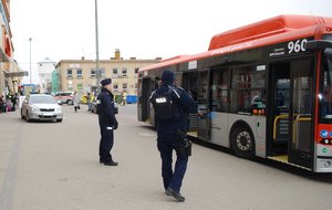 Policjanci pilnują autobusu, którym obywatele Ukrainy zostaną przewiezieni do miejsca noclegowego.