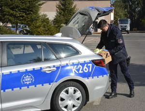 Zdjęcie kolorowe wykonane w porze dziennej -przedstawia pokój Komendy Miejskiej Policji w Przemyślu w którym są  składowane dary dla uchodźców z Ukrainy.