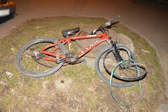 Zniszczony czerwony rower, leżący na ziemi w wyniku potrącenia 13-latka