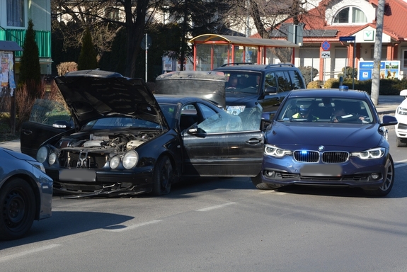 Zdjęcie kolorowe wykonane w porze dziennej -przedstawia ul. Św. Brata Alberta w Przemyślu. Na pierwszym planie po prawej stroi widoczny radiowóz nieoznakowany marki BMW  w kolorze granatowym a po lewej rozbity samochód marki mercedes w granatowym kolorze.