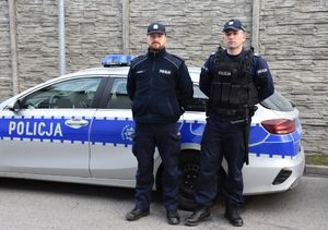 Dwóch policjantów przed radiowozem