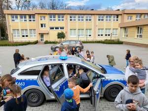 na fotografii policyjny radiowóz a wokół niego grupa dzieci