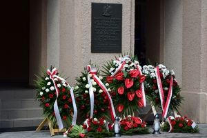 Kwiaty i wieńce pod tablicami przy wejściu do budynku KWP w Rzeszowie