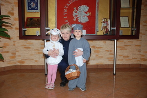 Zdjęcie kolorowe wykonane w porze dziennej –przedstawia dwoje przedszkolaków przebranych za baranka i zajączka składają życzenia Wielkanocne pracownikom komendy.