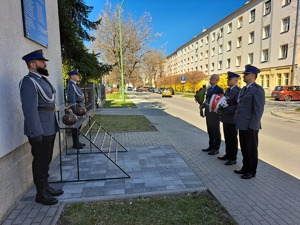 policjanci przed tablicą zamieszczoną na budynku KPP Mielec oddają hołd poległym policjantom