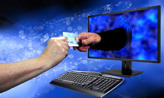 Na niebieskim tle widoczny monitor w którym widoczna jest ręka przekazująca kartę do innej ręki