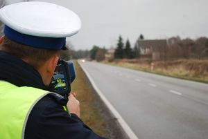 Policjant ruchu drogowego mierzący prędkość pojazdu