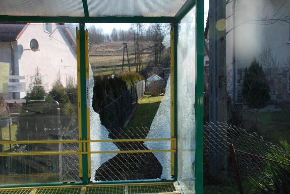 Fragment wiaty przystankowej z uszkodzonym elementem w postaci rozbitego szkła