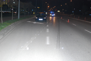 Zdjęcie kolorowe wykonane w porze nocnej-przedstawia miejsce zdarzenia drogowego w Przemyślu na ul. Lwowskiej. Na pierwszym planie widoczny jest pojazd –m-ki volkswagen w granatowym kolorze biorący udział w zdarzeniu, oraz na jezdni widoczne są ślady hamowania pojazdu. W tle zdjęcie widoczny radiowóz policyjny oznakowany z włączonymi sygnałami świetlnymi