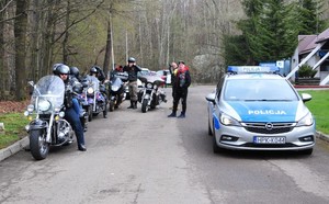 policyjny radiowóz zaparkowany obok grupy motocyklistów w czasie trwania akcji