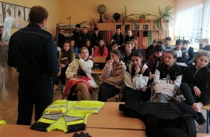 Policjanci podczas spotkania z dziećmi na dniach otwartych. W środku kadru policjant zwrócony twarzą do uczniów, siedzących na krzesłach.