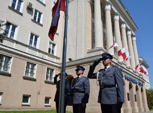 policjanci oddający honor podczas wciągania flagi na maszt