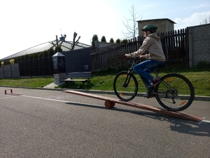 Na zdjęciu znajduje się dziecko jadące na rowerze po torze przeszkód