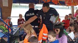 policjanci rozdają elementy odblaskowe podczas spotkania z dziećmi