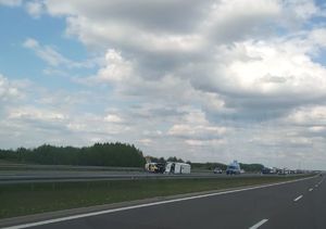 Miejsce zdarzenia - wypadek na autostradzie, na jezdni na boku leży samochód dostawczy