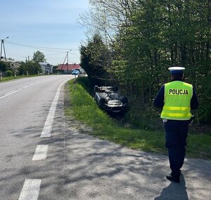 Miejsce zdarzenia drogowego w Kolbuszowej Dolnej. Na zdjęciu policjanci udzielający pomocy poszkodowanej kobiecie.