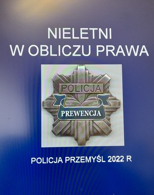 Zdjęcie przedstawia slajd w kolorze niebieskim na którym widnieje napis w białym kolorze „Nieletni w obliczu prawa” następnie pod napisem jest umieszczona policyjna odznaka z napisem Policja oraz Prewencja a pod odznaka napis „Policja Przemyśl 2022r”