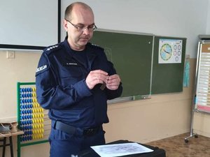 Zdjęcia przedstawiają policjanta podczas zajęć w klasie lekcyjnej.
