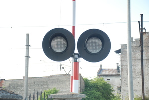 Zdjęcie kolorowe wykonane w porze dziennej  przedstawia sygnalizację świetlna kolejową.