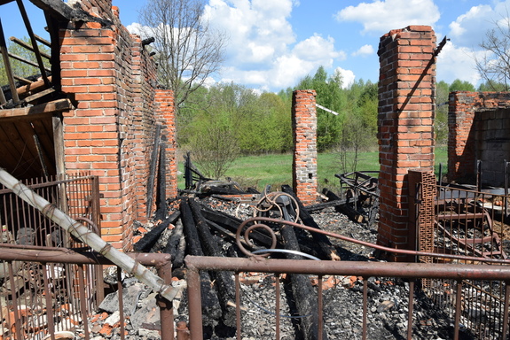 Na zdjęciu znajduje się spalona stodoła z murowanymi z cegły pozostałościami w porze dziennej