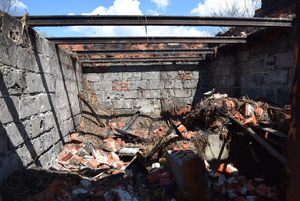Na zdjęciu znajdują się murowane ściany spalonej stodoły bez dachu który uległ spaleniu