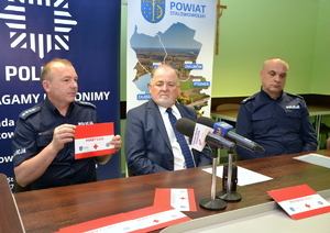Na zdjęciu znajduje się dwóch policjantów oraz starosta stalowowolski siedzący przy stole
