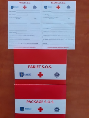 Na zdjęciu znajdują się dwie koperty koloru biało czerwonego z napisem pakiet s.o.s. oraz dwie białe karty z miejscami do wykonania wpisu o danych osobowych