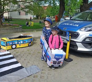 na zdjęciu dzieci bawiące się autochodzikiem - radiowozem policyjnym