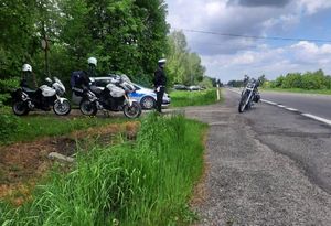 Policjant podczas kontroli drogowej. Obok niego znajdują się motocykle