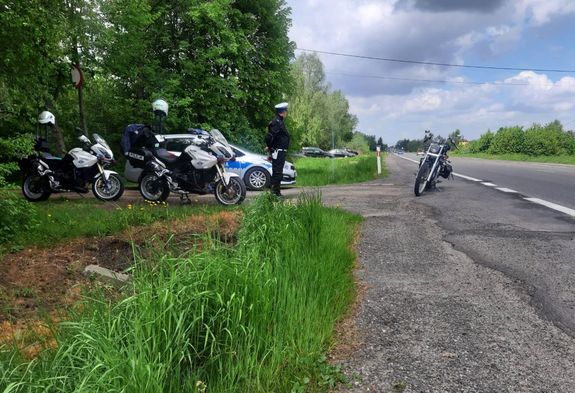 Policjant podczas kontroli drogowej. Obok niego znajdują się motocykle