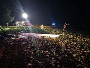 Pora nocna - miejsce wypadku lotniczego, na polu leży spalony samolot, widać jedno skrzydło. W tle wóz strażacki i kilka osób oraz reflektor oświetlający miejsce zdarzenia