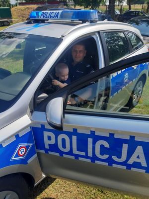 Policjant z dzieckiem w radiowozie