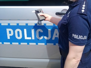 Na zdjęciu policjantka, która trzyma urządzenie do badania stanu trzeźwości
