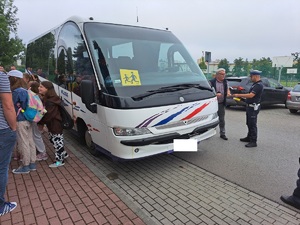 na zdjęciu bus kontrolowany przez policjantów, oraz dzieci czekające na wejście do busa, policjant oraz kierowca