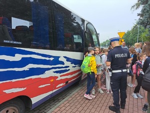 policjant podczas kontroli wraz z dziećmi które przyglądają się jego pracy