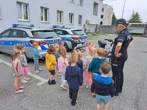 na fotografii policjantka wraz z dziećmi pokazuje najmłodszym uczestnikom spotkania policyjne rowery