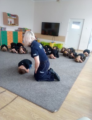 policjantka ćwiczy z dziećmi bezpieczne zachowania