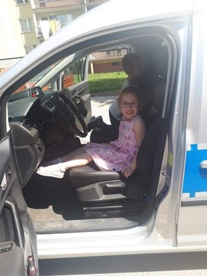 Dziewczynka siedzi w radiowozie policyjnym