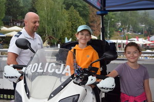 dzieci siedzące na motocyklu z policjantem