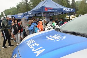 policyjny radiowóz i policyjne stoisko promocyjne