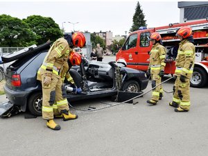na zdjęciu pokaz ratownictwa drogowego, strażacy rozcinają wrak pojazdu przy użyciu hydraulicznego sprzętu