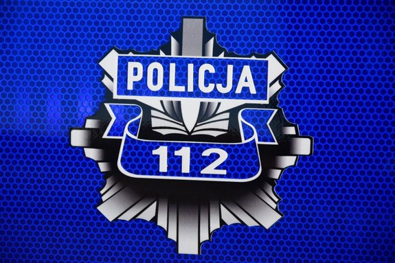 Na zdjęciu znajduje się policyjne logo z napisem policja i numerem alarmowym 112