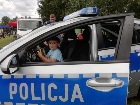 Chłopiec siedzący w policyjnym  radiowozie