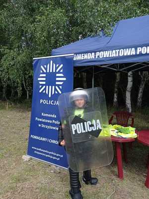 Na zdjęciu chłopiec ubrany w policyjny hełm i tarczę