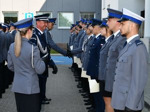 Pierwszy zastępca komendanta wojewódzkiego policji w Rzeszowie wręcza akty mianowania policjantom stojącym w szeregu