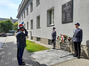 Komendant Powiatowy wraz z Zastępcą składają kwiaty przed tablicą znajdującą się na budynku Komendy Powiatowej Policji w Mielcu